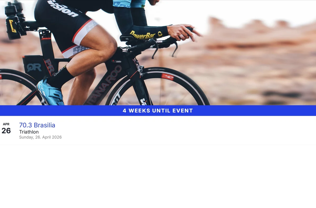 Triathletin im Aero-Griff auf dem Zeitfahrrad, Race-Day-Atmosphäre